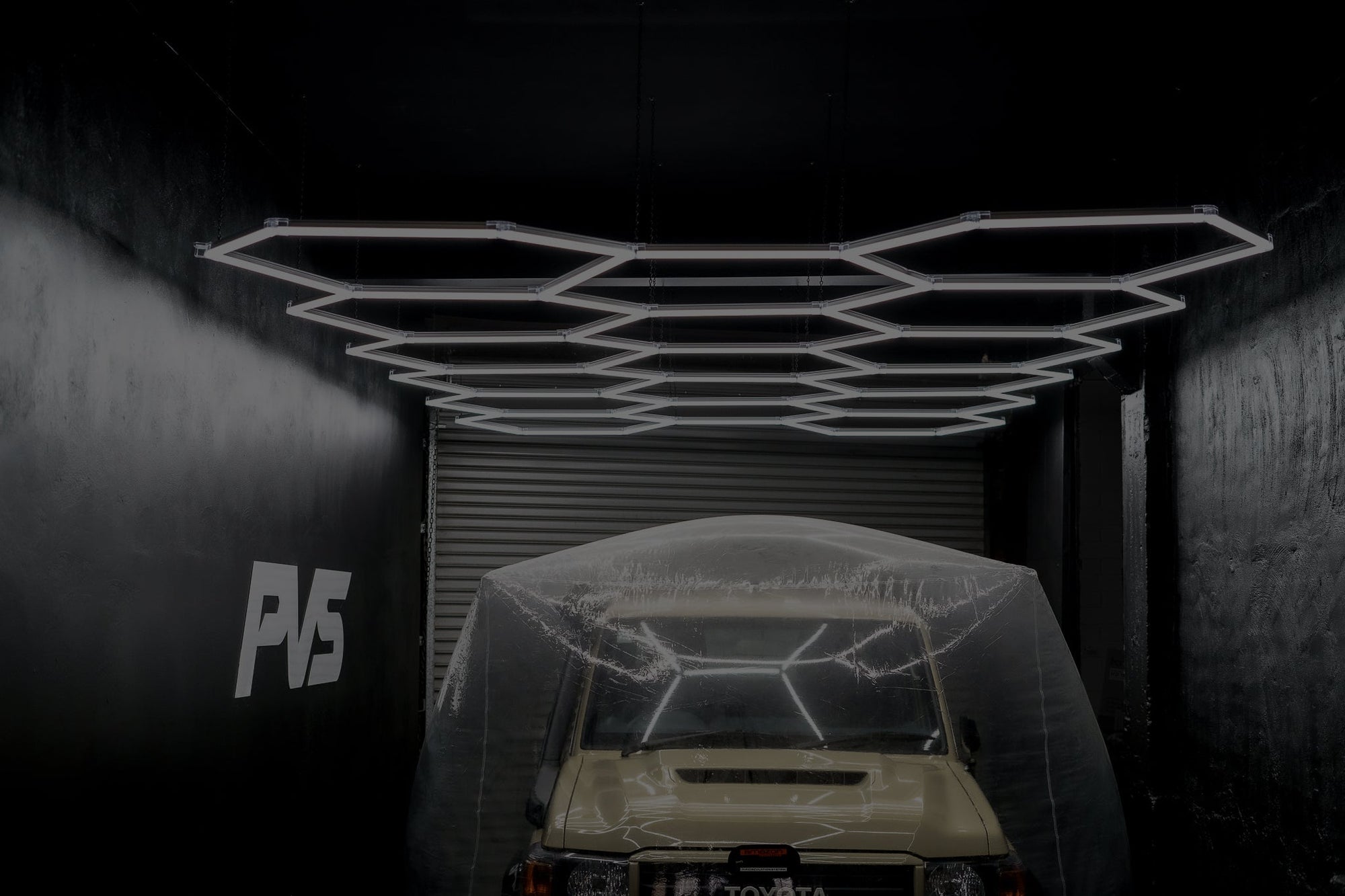 Black frame HEXA hexagon LED panel clusters mounted on a garage ceiling providing even task lighting